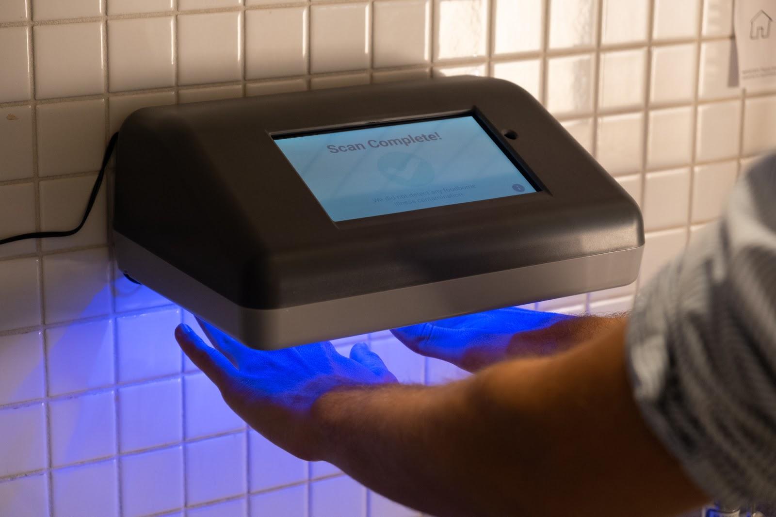A hand holding a touch screen device
Description automatically generated with low confidence